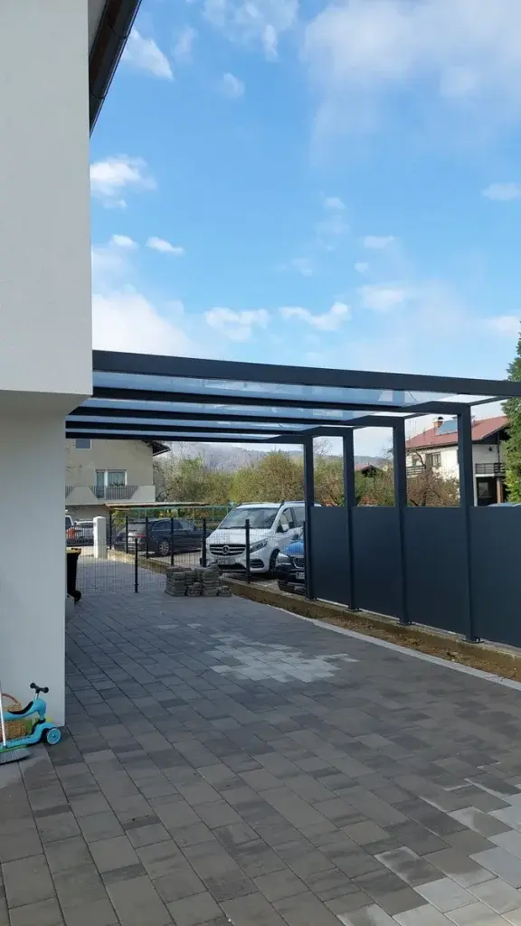 Nadstrešek za avtomobila iz prozornega kaljenega lepljenega stekla na jekleni konstrukciji. Pokrita garaža za 2 avtomobila po